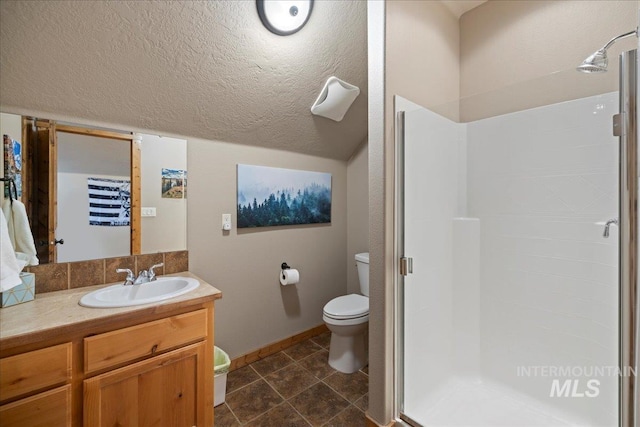 bathroom featuring vanity, toilet, a shower with door, and vaulted ceiling