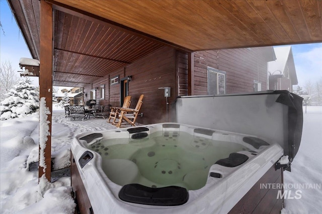 snow covered patio with a hot tub