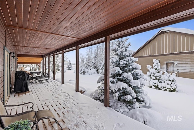 snow covered deck with a grill