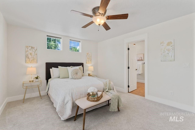 bedroom featuring light carpet, baseboards, ceiling fan, and connected bathroom