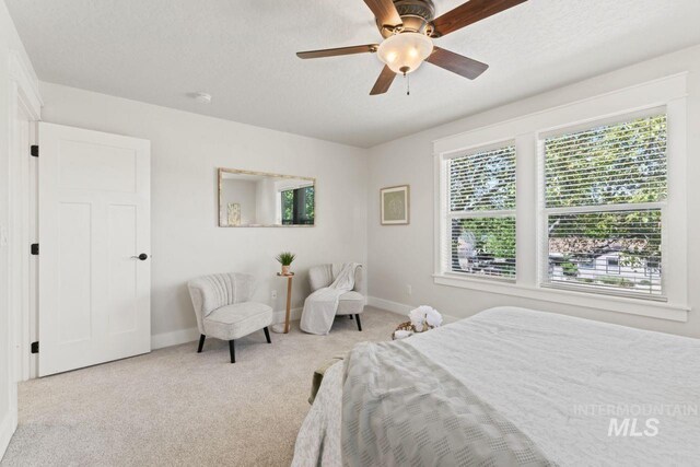 carpeted bedroom with baseboards, ceiling fan, and a textured ceiling