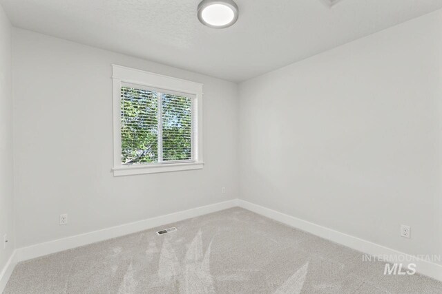 spare room with carpet floors and baseboards