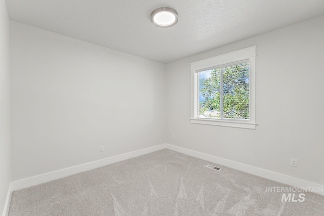 spare room featuring baseboards and carpet flooring