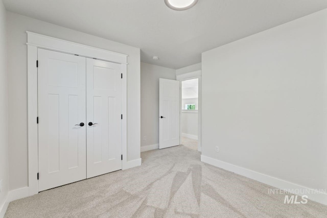unfurnished bedroom with baseboards, carpet, and a closet