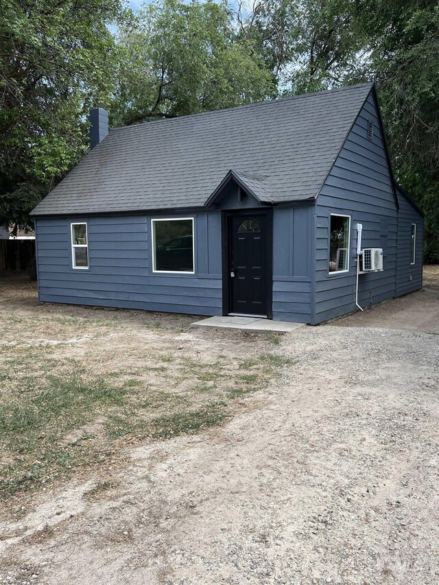 956 8th Ave N, Payette, ID 83661 - view of front facade with a chimney, cooling unit, and roof with shingles