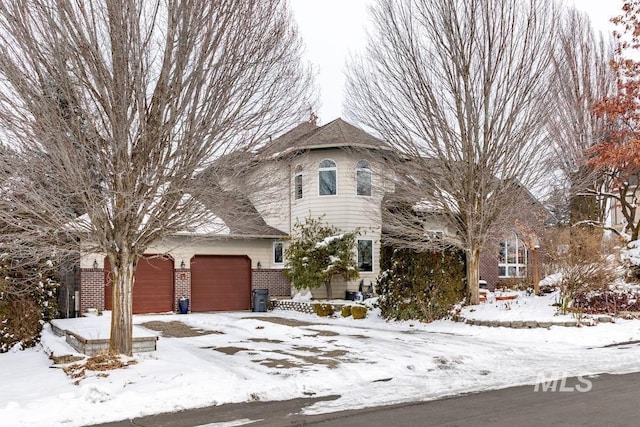 view of front facade featuring brick siding and an attached garage