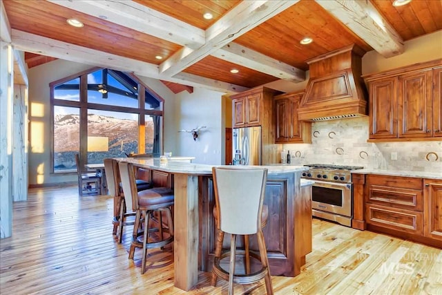 kitchen with a kitchen island, custom exhaust hood, light hardwood / wood-style flooring, and appliances with stainless steel finishes