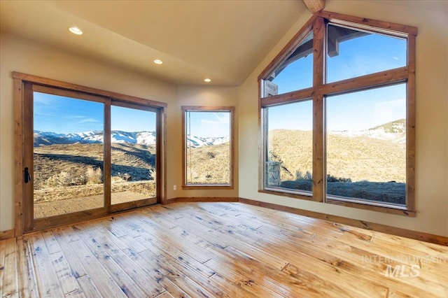 unfurnished sunroom featuring a mountain view and vaulted ceiling