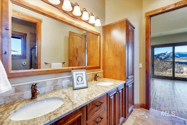 bathroom with a mountain view, hardwood / wood-style floors, double vanity, and a wealth of natural light