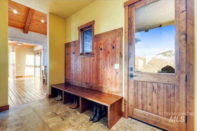 mudroom featuring light tile floors, wooden ceiling, and beamed ceiling