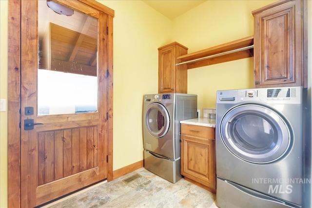 clothes washing area featuring light tile floors, cabinets, washer and dryer, and wooden ceiling