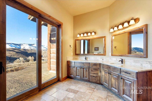 bathroom featuring tile floors, double vanity, a healthy amount of sunlight, and a mountain view