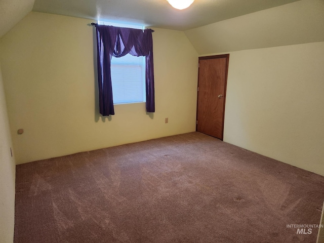 bonus room with lofted ceiling and carpet flooring