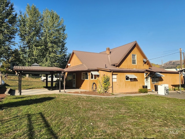 rear view of house with a yard and a patio