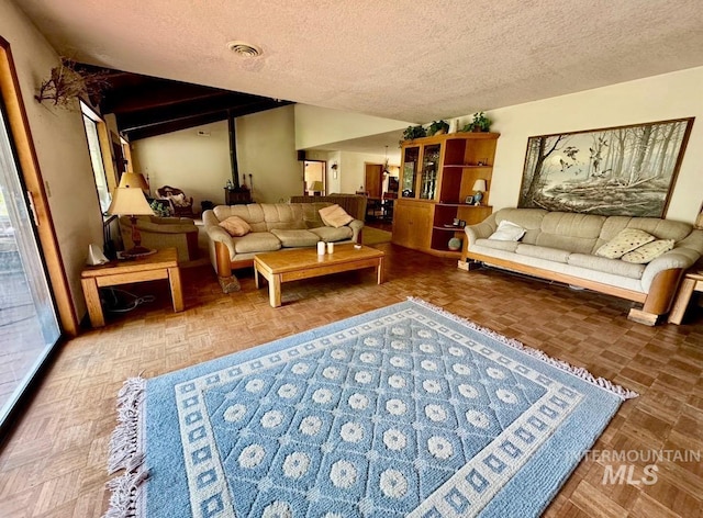 living area featuring a textured ceiling, vaulted ceiling, and visible vents