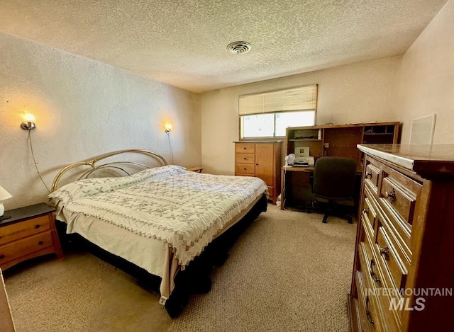 bedroom featuring light carpet, visible vents, a textured ceiling, and a textured wall