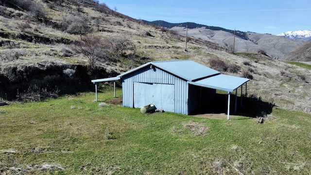 view of pole building featuring a lawn and a mountain view