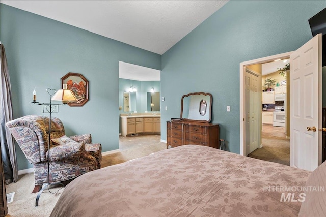 carpeted bedroom featuring connected bathroom and vaulted ceiling