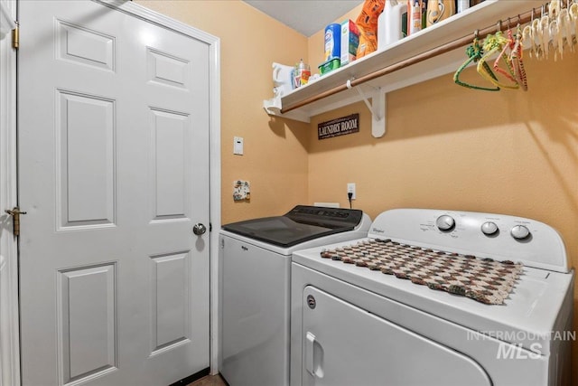 clothes washing area featuring separate washer and dryer