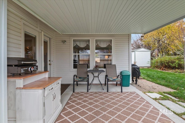 view of patio / terrace with a grill and a shed