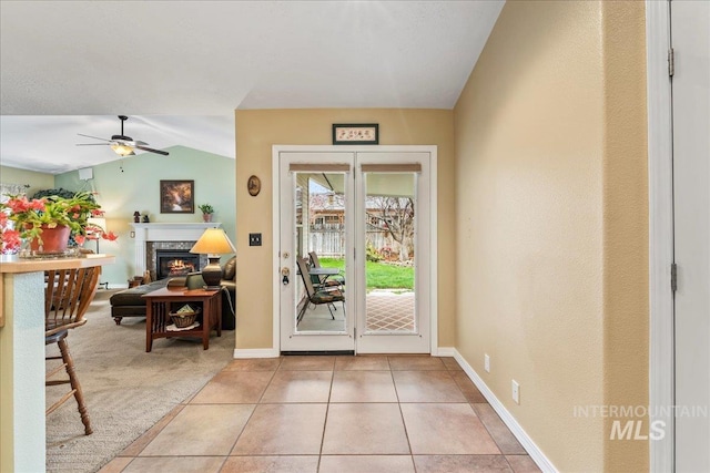 foyer entrance with ceiling fan, light tile patterned flooring, and vaulted ceiling