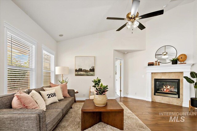 8613 W Thunder Mountain Dr, Boise, ID 83709 - living room featuring lofted ceiling, baseboards, wood finished floors, a tiled fireplace, and a ceiling fan