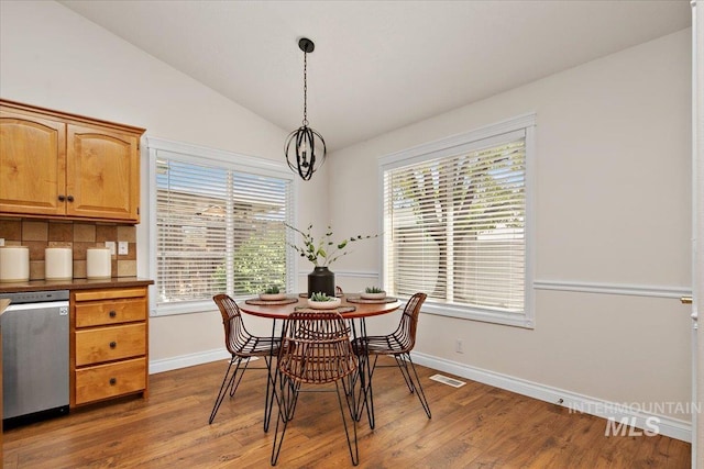 8613 W Thunder Mountain Dr, Boise, ID 83709 - dining space with baseboards, visible vents, wood finished floors, and lofted ceiling
