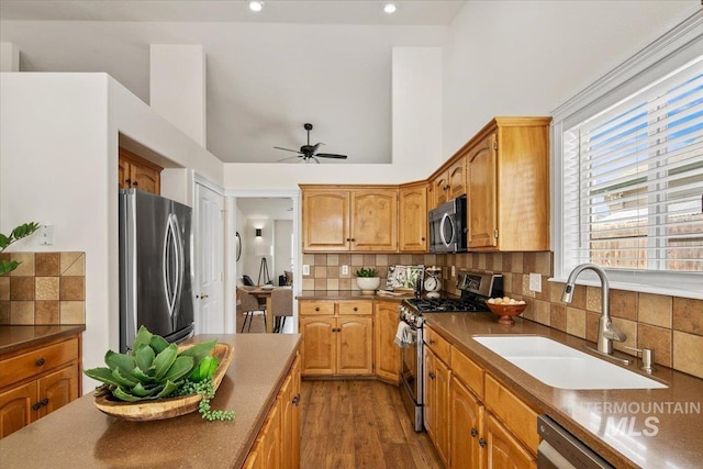8613 W Thunder Mountain Dr, Boise, ID 83709 - kitchen with a sink, stainless steel appliances, ceiling fan, tasteful backsplash, and dark countertops