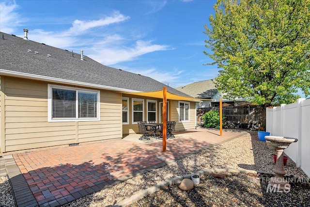 8613 W Thunder Mountain Dr, Boise, ID 83709 - rear view of house featuring roof with shingles, a fenced backyard, and a patio area