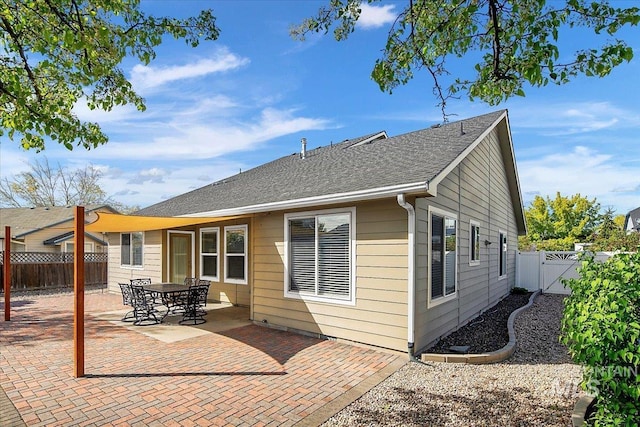 8613 W Thunder Mountain Dr, Boise, ID 83709 - back of house with roof with shingles, a gate, a fenced backyard, and a patio area
