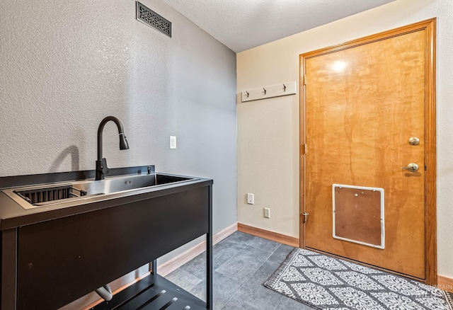 14060 Deerfield, Mccall, ID 83638 - laundry room with a sink, dark tile patterned floors, and baseboards