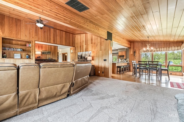 14060 Deerfield, Mccall, ID 83638 - living area with wood walls, a chandelier, wooden ceiling, carpet flooring, and a ceiling fan
