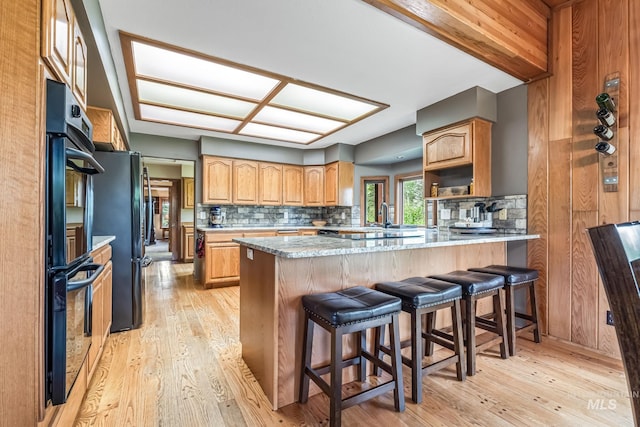 14060 Deerfield, Mccall, ID 83638 - kitchen with black appliances, a peninsula, decorative backsplash, and light wood-style flooring