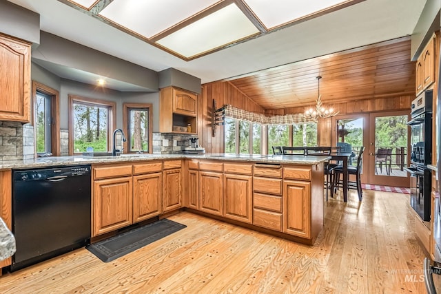 14060 Deerfield, Mccall, ID 83638 - kitchen with black appliances, a sink, a peninsula, decorative backsplash, and light wood finished floors