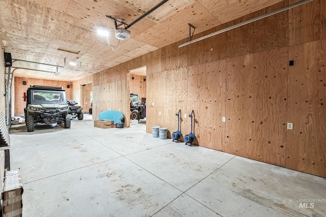 14060 Deerfield, Mccall, ID 83638 - garage featuring a garage door opener and wooden walls