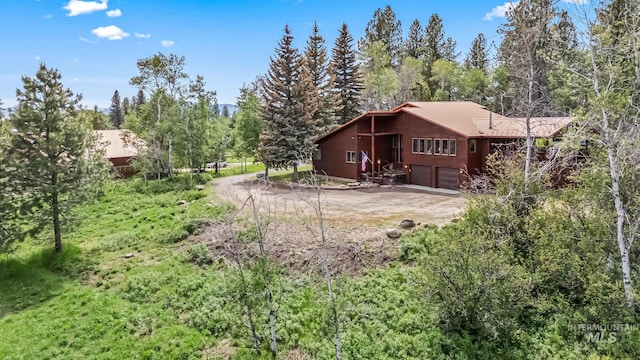 14060 Deerfield, Mccall, ID 83638 - back of property with dirt driveway, a garage, and a forest view