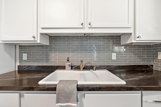 kitchen with decorative backsplash, sink, and white cabinetry