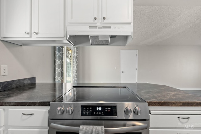 kitchen featuring white cabinetry, a textured ceiling, and stainless steel electric range