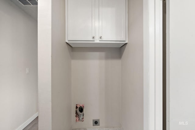 laundry room featuring electric dryer hookup and cabinets