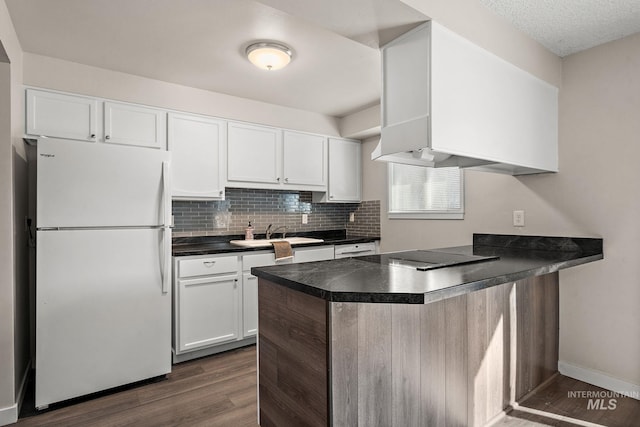 kitchen featuring kitchen peninsula, sink, white refrigerator, white cabinets, and black electric cooktop