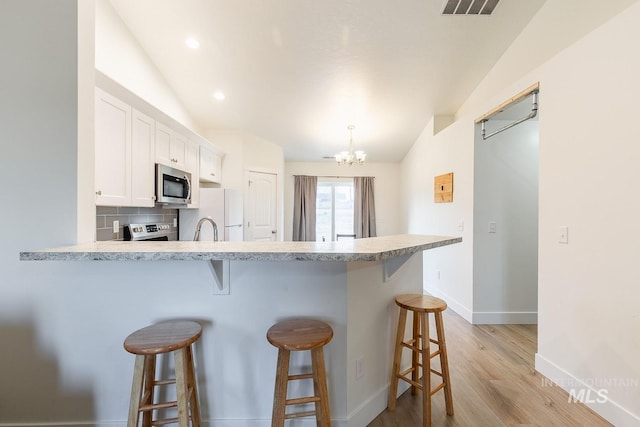 kitchen featuring white cabinetry, lofted ceiling, and a breakfast bar