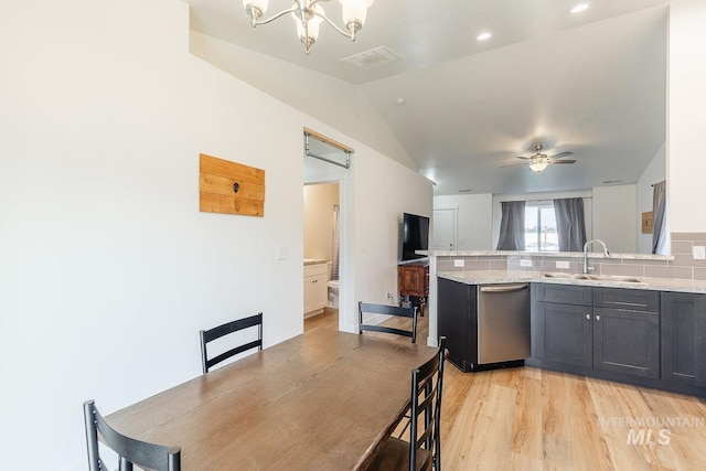 kitchen with ceiling fan with notable chandelier, light stone countertops, dishwasher, sink, and light hardwood / wood-style flooring