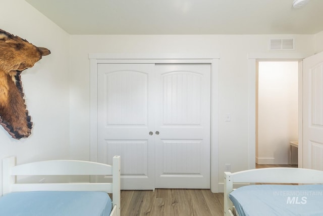 bedroom with a closet and light hardwood / wood-style floors