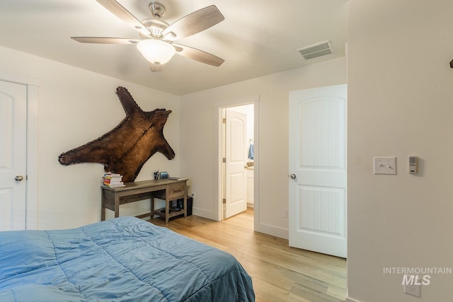 bedroom featuring ceiling fan, ensuite bath, and light wood-type flooring