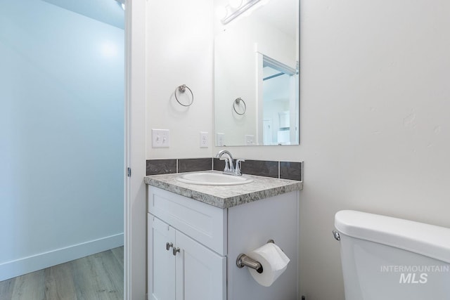 bathroom featuring toilet, vanity, and wood-type flooring