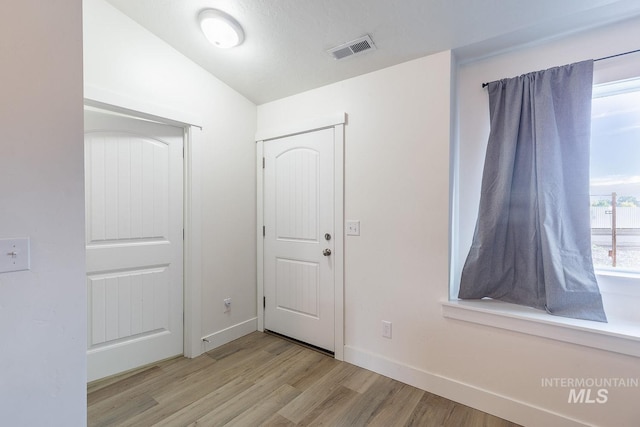 interior space featuring vaulted ceiling and light hardwood / wood-style floors