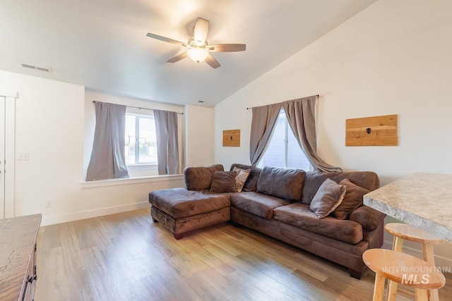 living room featuring ceiling fan, lofted ceiling, and light hardwood / wood-style floors