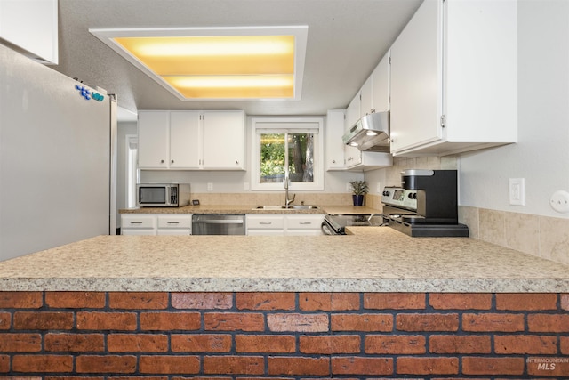 6835 W Freemont St, Boise, ID 83704 - kitchen featuring stainless steel appliances, under cabinet range hood, light countertops, and a peninsula