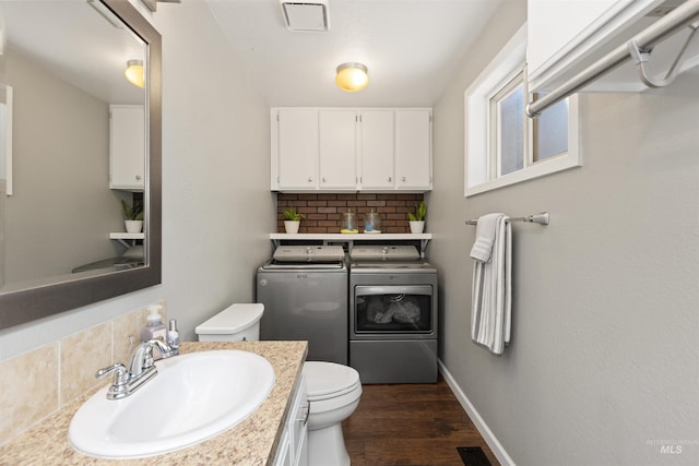 6835 W Freemont St, Boise, ID 83704 - bathroom with independent washer and dryer, decorative backsplash, wood finished floors, and vanity