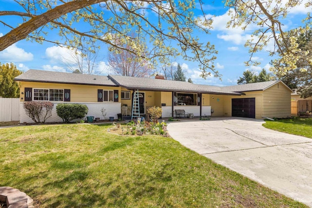 ranch-style home with concrete driveway, fence, an attached garage, a front yard, and a chimney